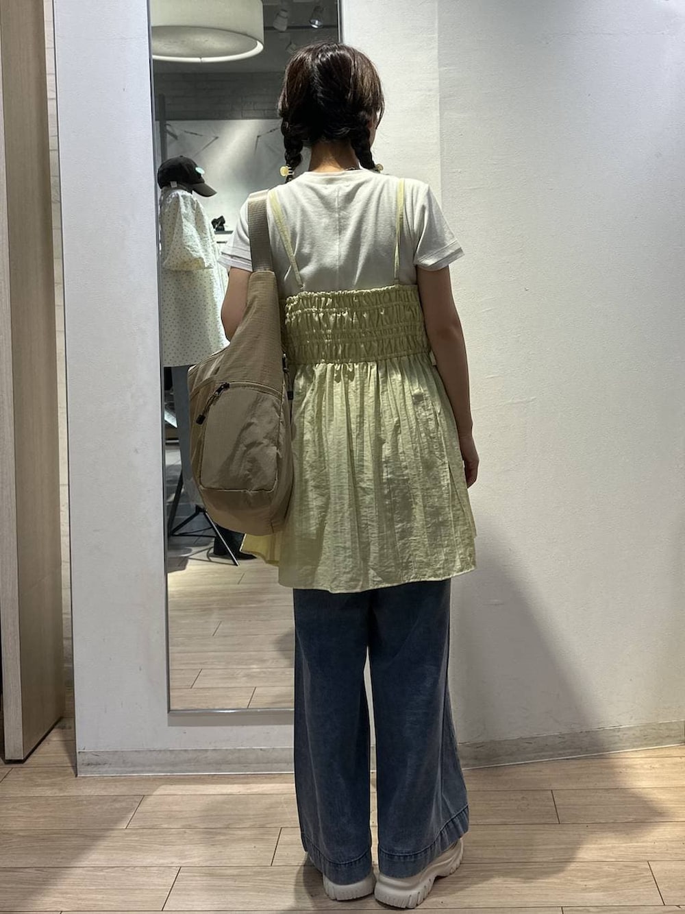 ベージュ系のショルダーバッグ、イエロー系のワンピース、ブルー系のデニムパンツを着用したレディースの夏コーディネートの4枚目の写真