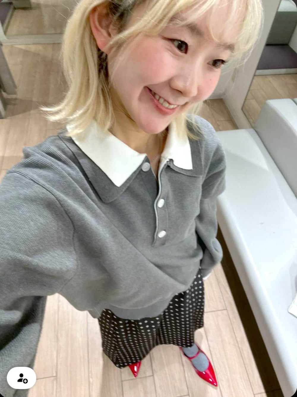 ブラック系のスカート、レッド系のパンプス、グレー系のニット/セーターを着用したレディースの冬コーディネートの3枚目の写真