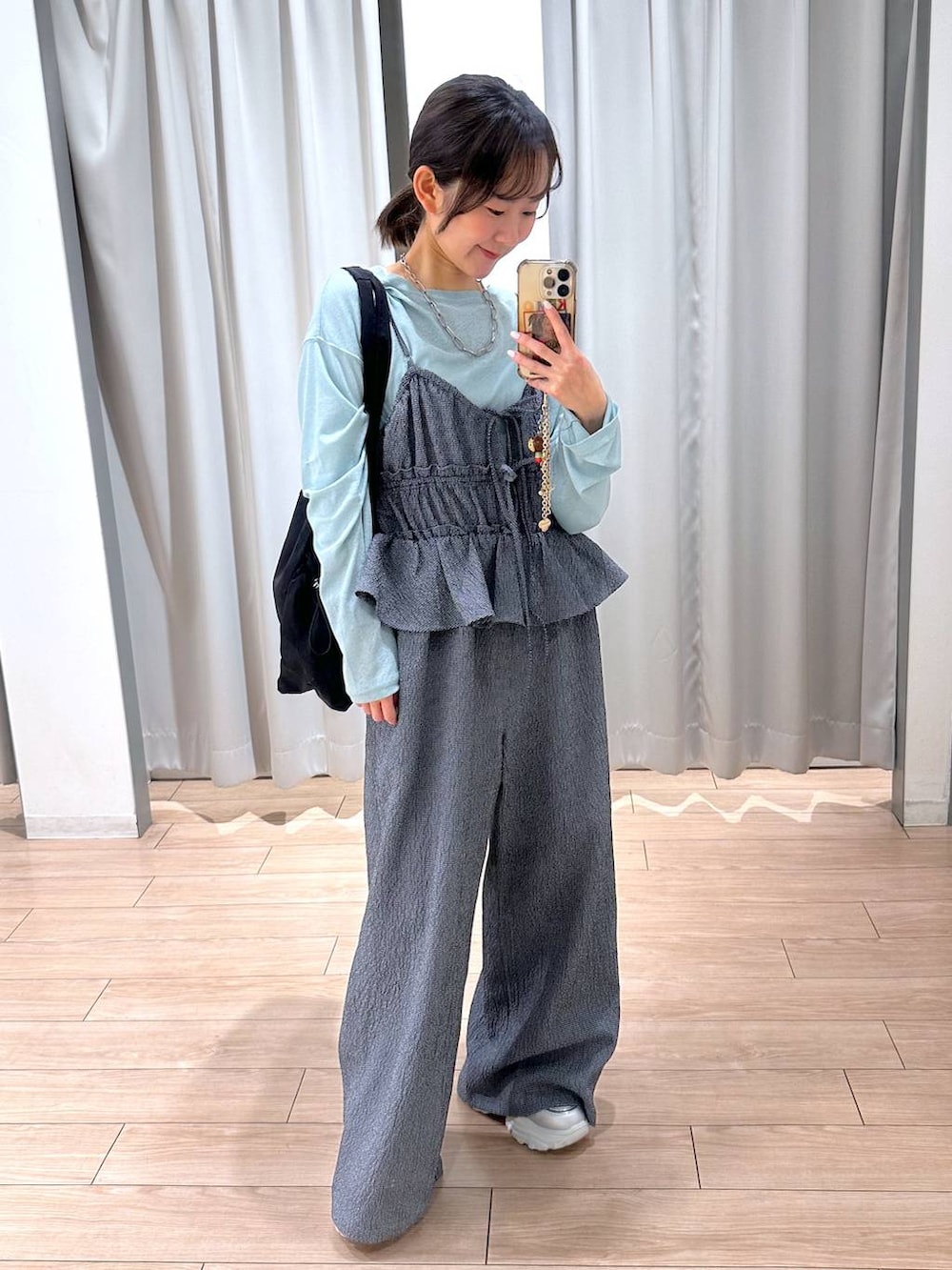 グリーン系のTシャツ/カットソー、ブラック系のトートバッグ、ブルー系のサロペット/オーバーオールを着用したレディースの春コーディネートの6枚目の写真