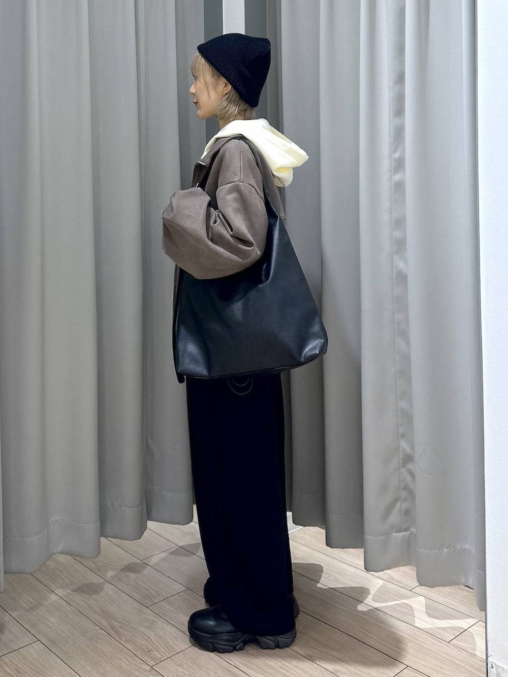 ベージュ系のTシャツ/カットソー、ブラック系のショルダーバッグ、ブラック系のブーツを着用したレディースの秋コーディネートの2枚目の写真