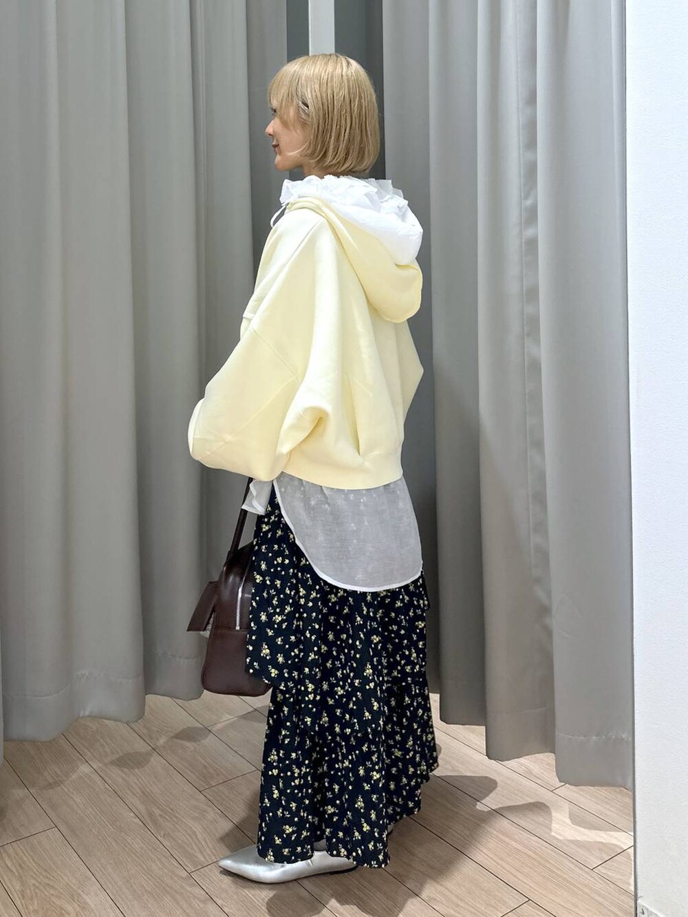 ブラウン系のボストンバッグ、ホワイト系のシャツ/ブラウス、シルバー系のパンプスを着用したレディースの秋コーディネートの3枚目の写真