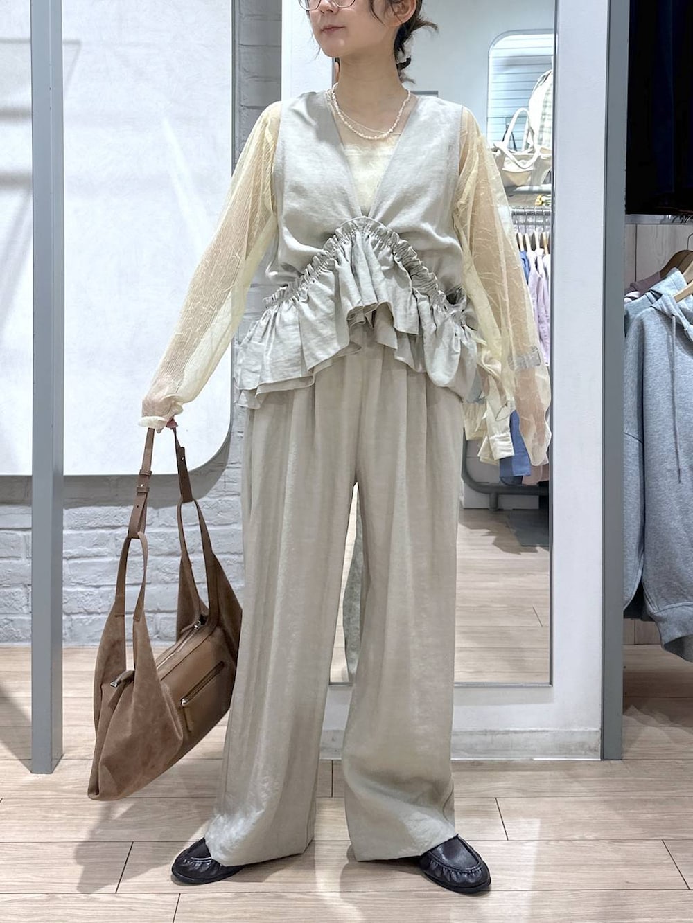 ゴールド系のタンクトップ、ブラック系のローファー、ブラウン系のショルダーバッグを着用したレディースの春コーディネートの2枚目の写真