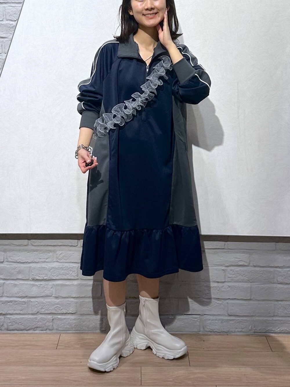 ホワイト系のブーツ、ブルー系のワンピース、グレー系のスマホグッズを着用したレディースの秋コーディネートの4枚目の写真