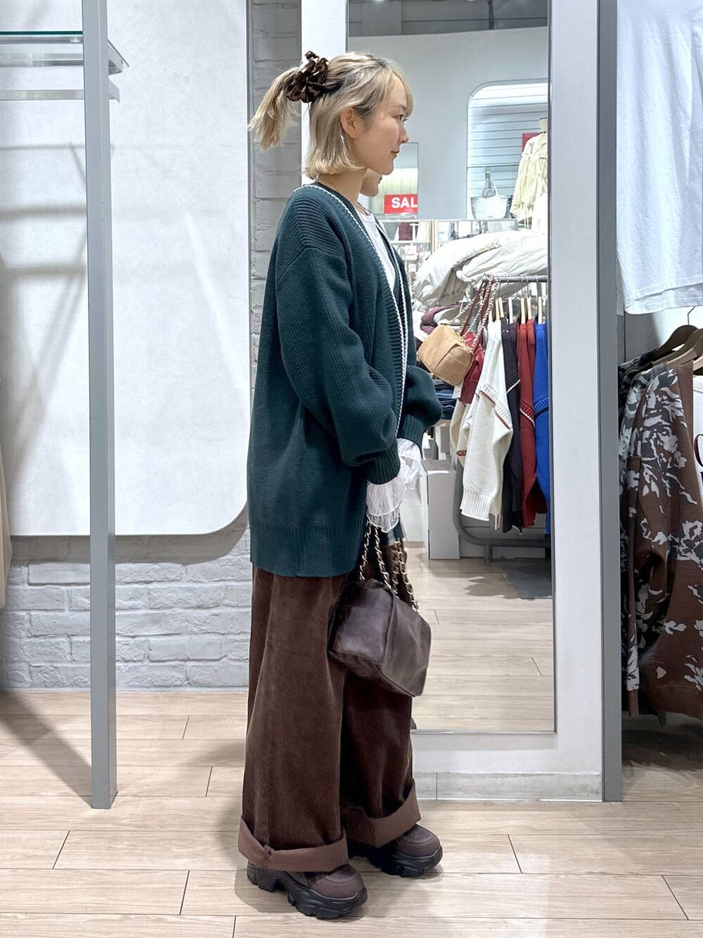 グリーン系のカーディガン/ボレロ、ブラウン系のその他パンツ、ホワイト系のTシャツ/カットソーを着用したレディースの秋コーディネートの4枚目の写真