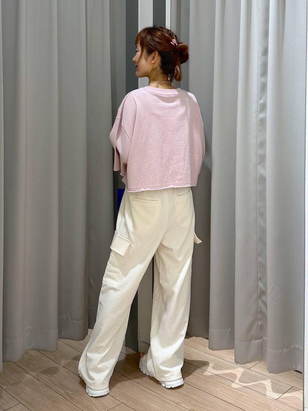 ホワイト系のサンダル、ピンク系のTシャツ/カットソー、ホワイト系のスラックスを着用したレディースの夏コーディネートの3枚目の写真