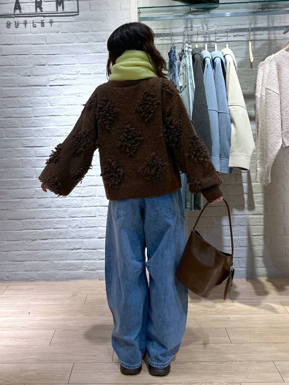 ブルー系のデニムパンツ、ブラック系のブーツ、ブラウン系のトートバッグを着用したレディースの冬コーディネートの4枚目の写真