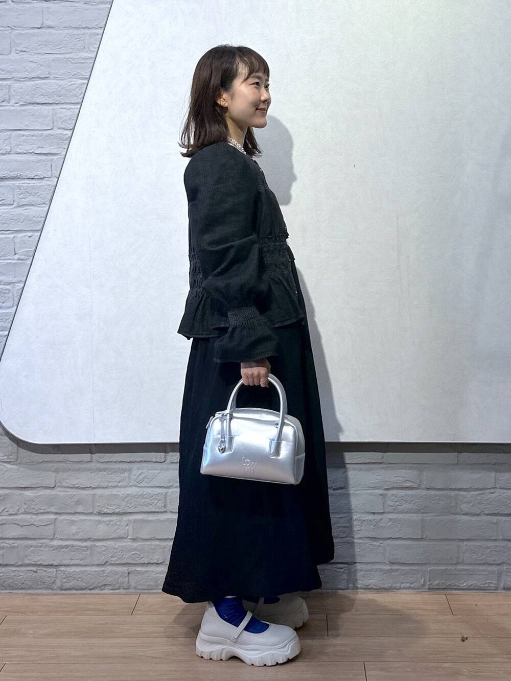 ブラック系のシャツ/ブラウス、ホワイト系のTシャツ/カットソー、ホワイト系のスニーカーを着用したレディースの秋コーディネートの4枚目の写真