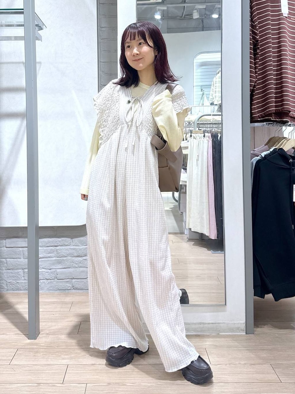 ベージュ系のサロペット/オーバーオール、イエロー系のTシャツ/カットソー、ブラウン系のローファーを着用したレディースの春コーディネートの5枚目の写真