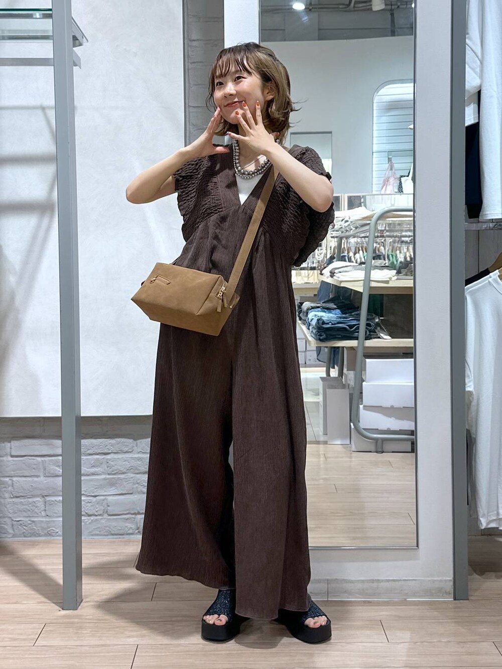 ホワイト系のTシャツ/カットソー、ブラック系のサンダル、ブラウン系のサロペット/オーバーオールを着用したレディースの夏コーディネートの4枚目の写真