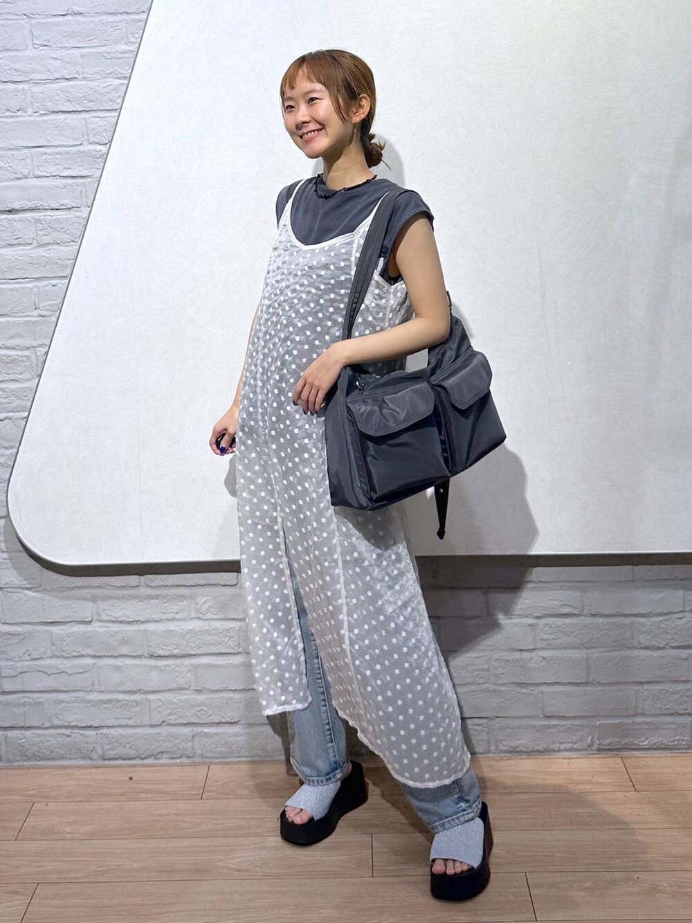 シルバー系のサンダル、ブルー系のデニムパンツ、ホワイト系のワンピースを着用したレディースの夏コーディネートの6枚目の写真