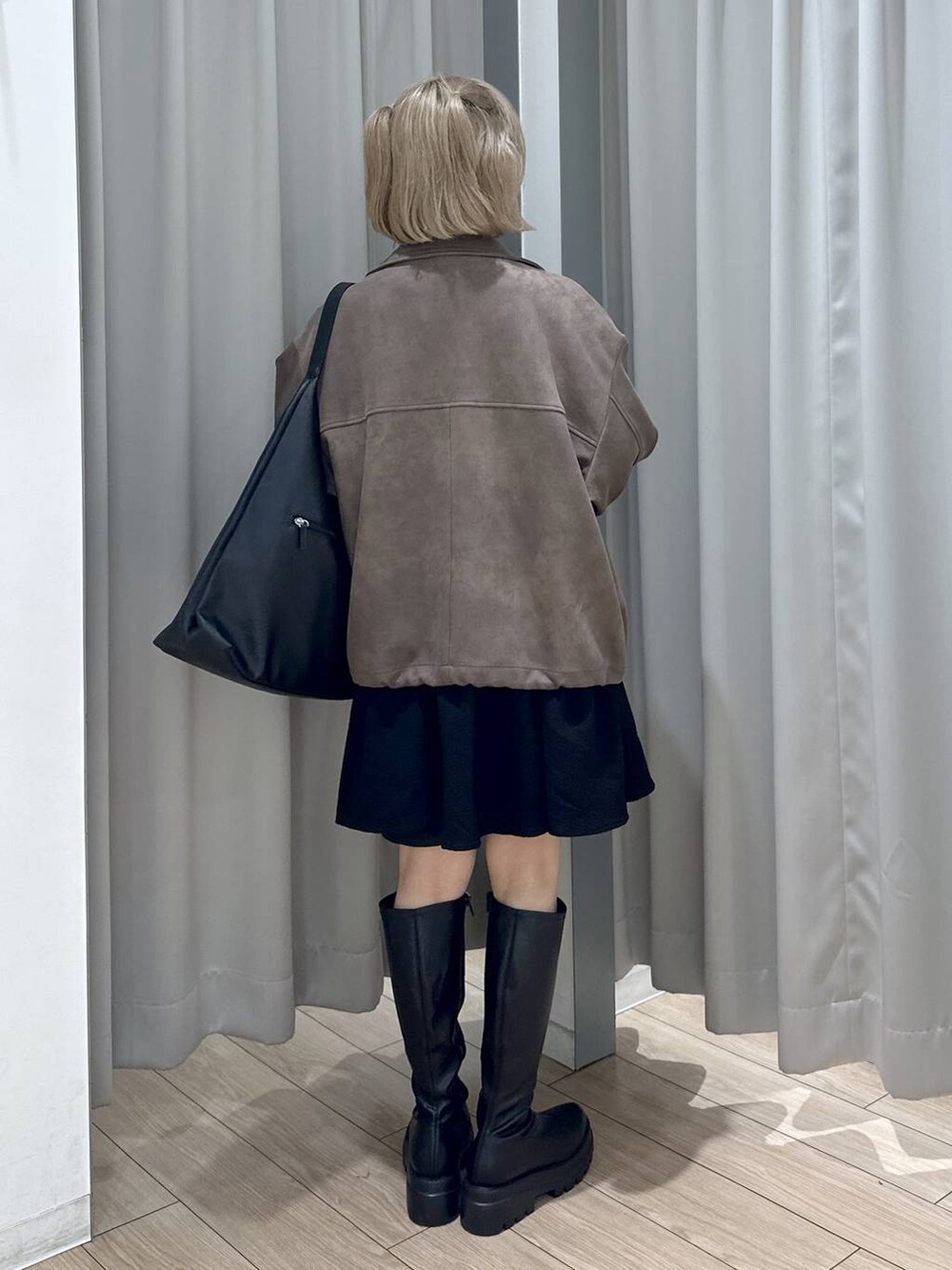 ブラック系のショルダーバッグ、ブラウン系のブルゾン、ブラック系のブーツを着用したレディースの秋コーディネートの4枚目の写真