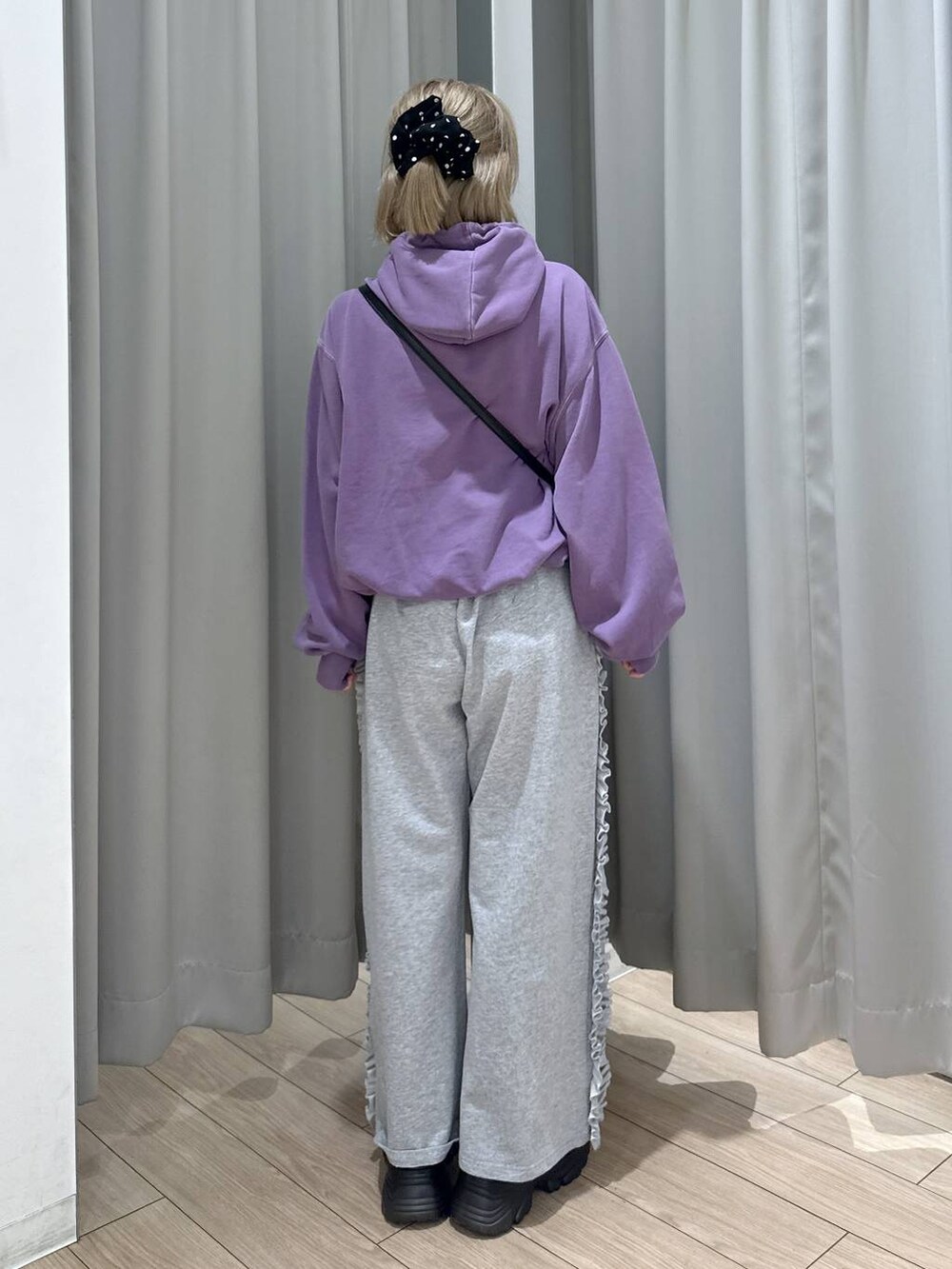 ブラック系のブーツ、パープル系のパーカー、その他のボストンバッグを着用したレディースの秋コーディネートの5枚目の写真