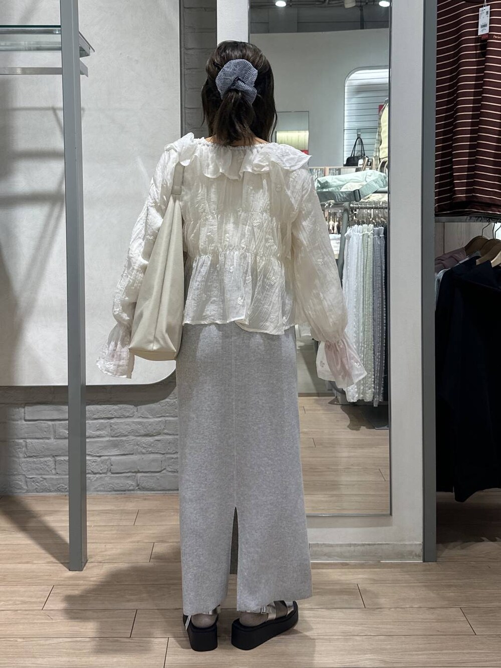 ベージュ系のTシャツ/カットソー、グレー系のスカート、ホワイト系のショルダーバッグを着用したレディースの春コーディネートの5枚目の写真