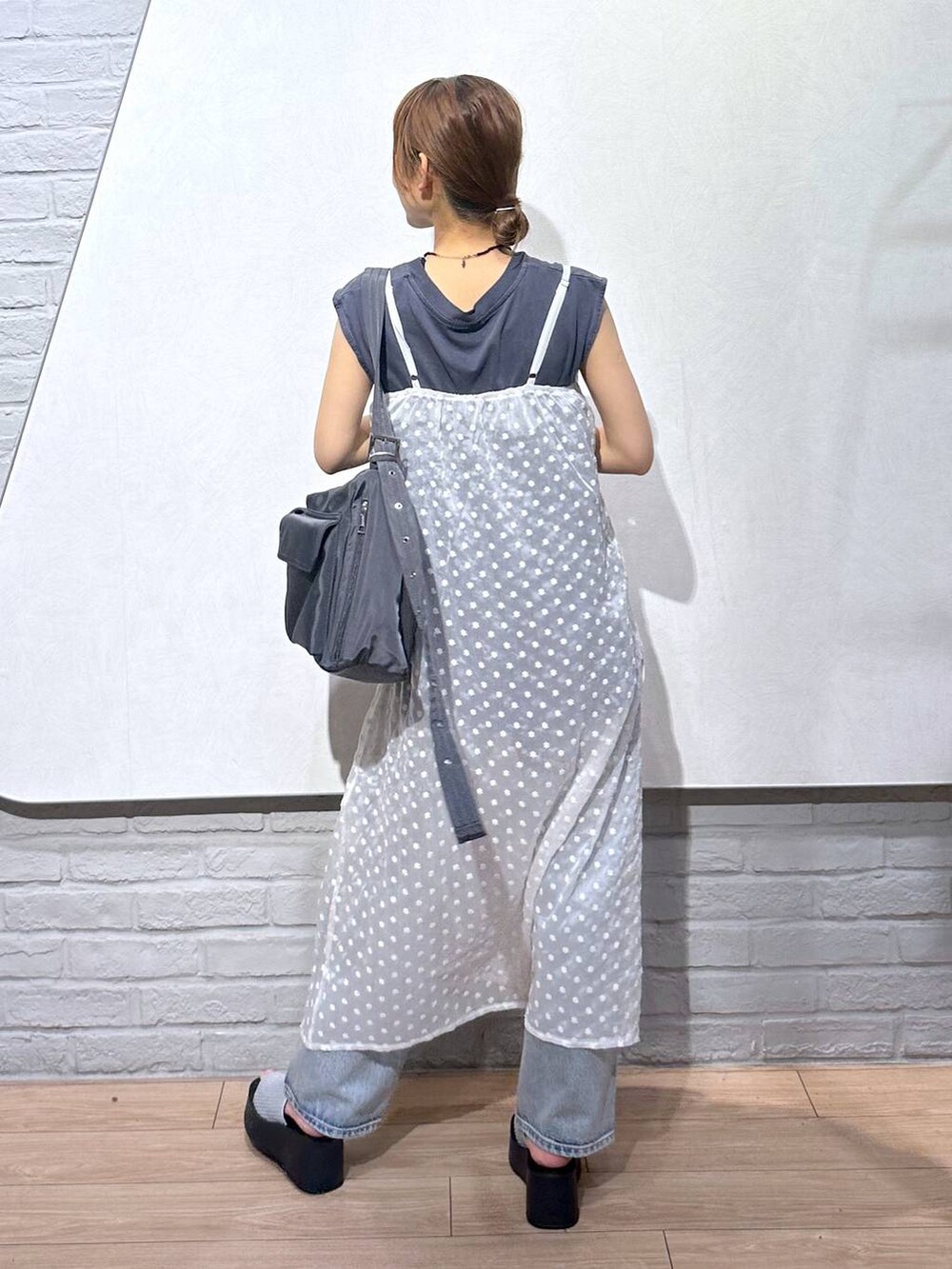 シルバー系のサンダル、ブルー系のデニムパンツ、ホワイト系のワンピースを着用したレディースの夏コーディネートの3枚目の写真