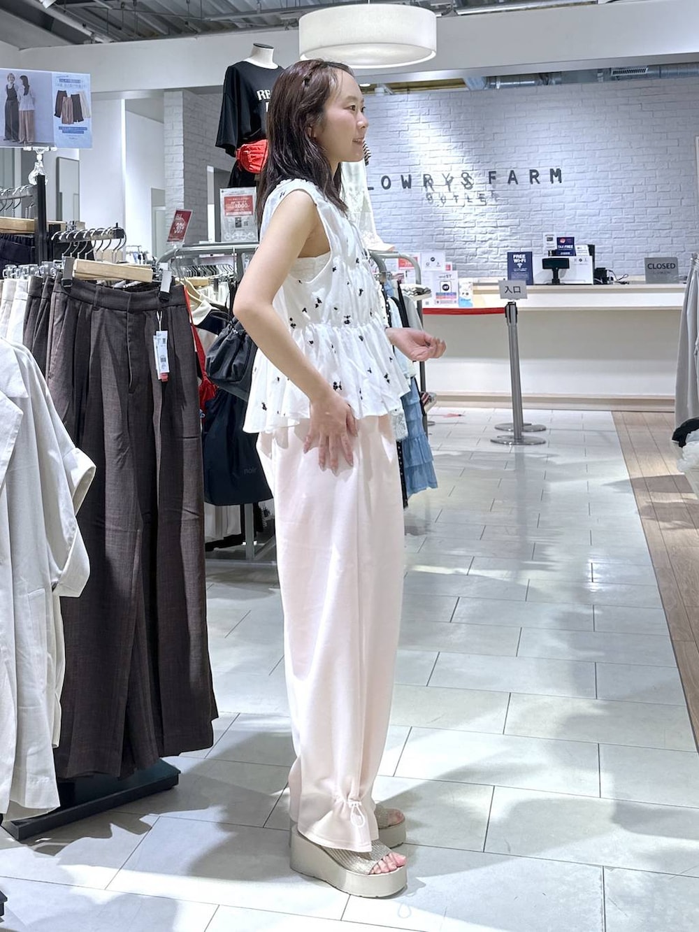 ピンク系のスウェットパンツ、ホワイト系のサンダル、ホワイト系のシャツ/ブラウスを着用したレディースの夏コーディネートの4枚目の写真