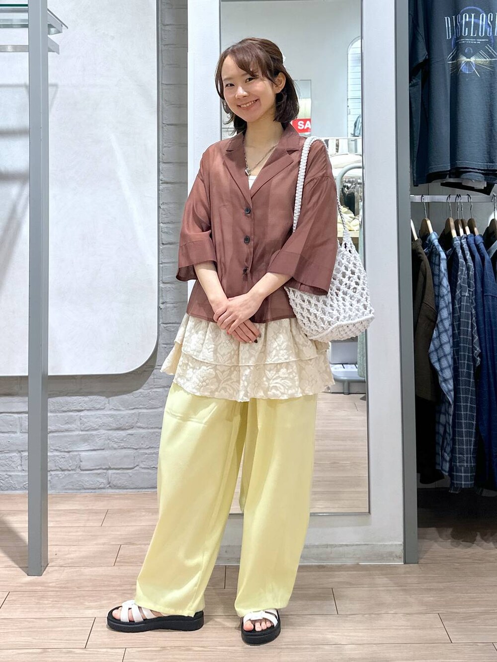 ホワイト系のサンダル、ホワイト系のトートバッグ、ブラウン系のシャツ/ブラウスを着用したレディースの夏コーディネートの5枚目の写真