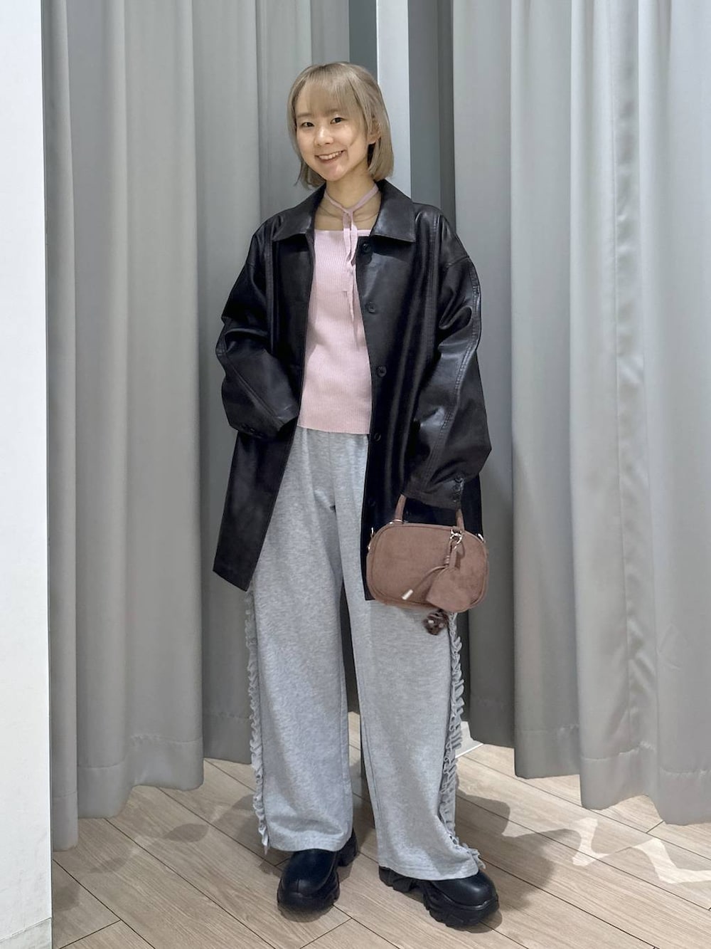 ブラック系のブーツ、ブラウン系のカバーオール、ピンク系のニット/セーターを着用したレディースの秋コーディネートの4枚目の写真