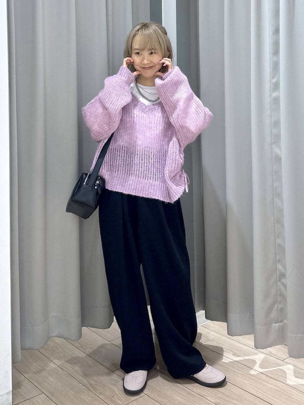 ピンク系のスニーカー、ブラック系のスウェットパンツ、ブラック系のショルダーバッグを着用したレディースの秋コーディネートの3枚目の写真