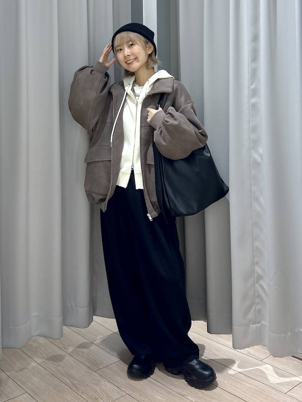 ベージュ系のTシャツ/カットソー、ブラック系のショルダーバッグ、ブラック系のブーツを着用したレディースの秋コーディネートの3枚目の写真