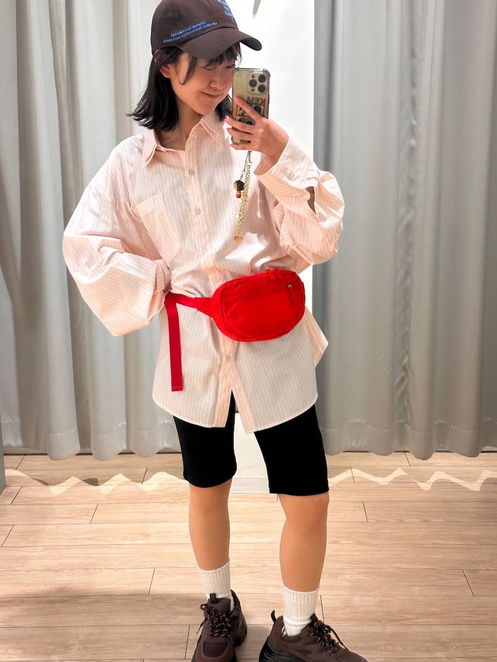 レッド系のボディバッグ/ウエストポーチ、ピンク系のシャツ/ブラウス、ブラック系のその他パンツを着用したレディースの春コーディネートの5枚目の写真