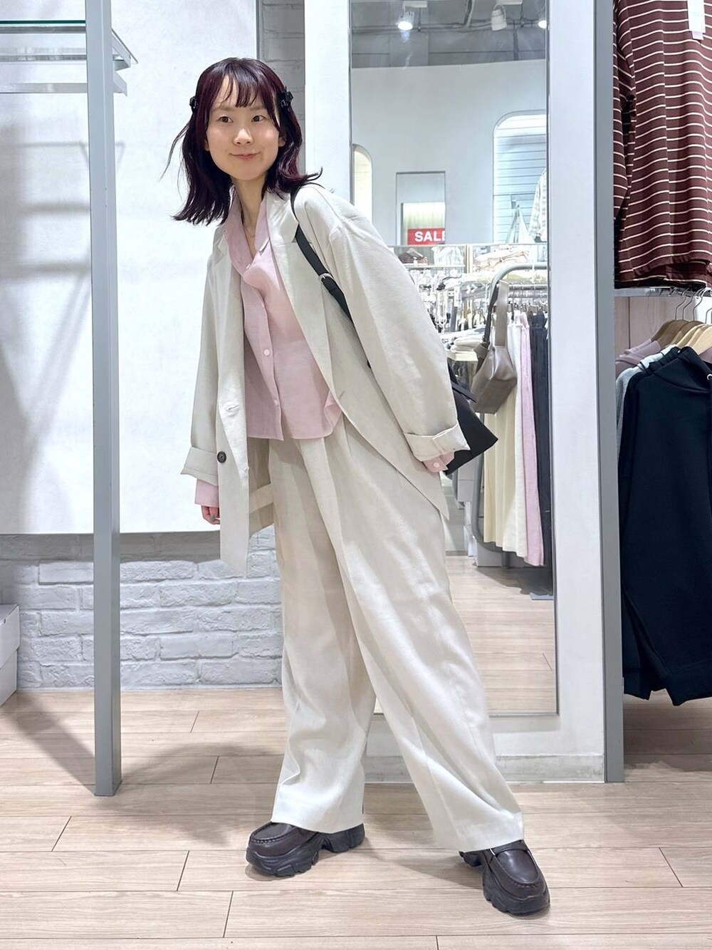 ブラック系のショルダーバッグ、ベージュ系のその他アウター、ベージュ系のその他パンツを着用したレディースの春コーディネートの7枚目の写真