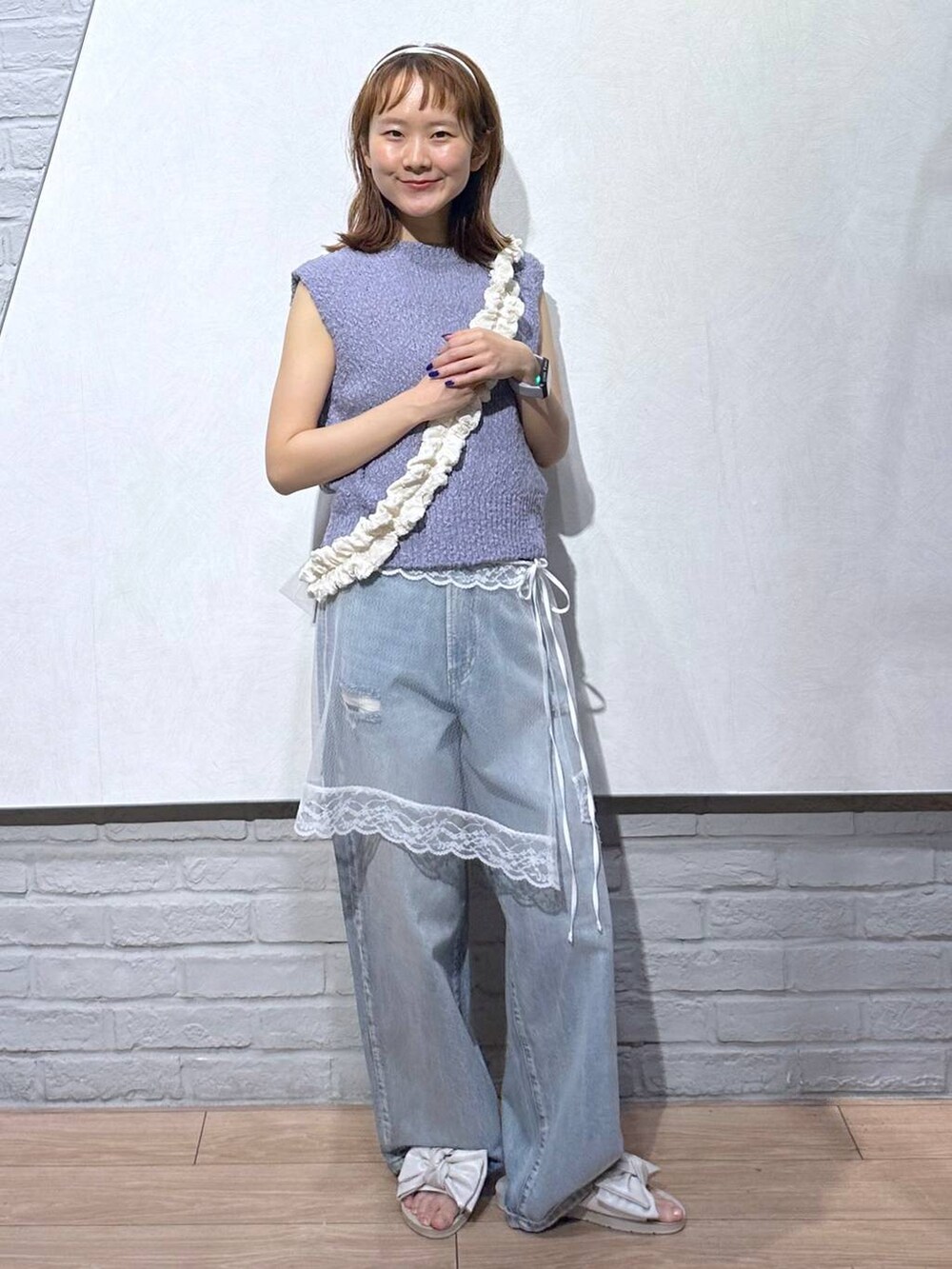 ホワイト系のサンダル、パープル系のベスト、ブルー系のデニムパンツを着用したレディースの夏コーディネートの4枚目の写真