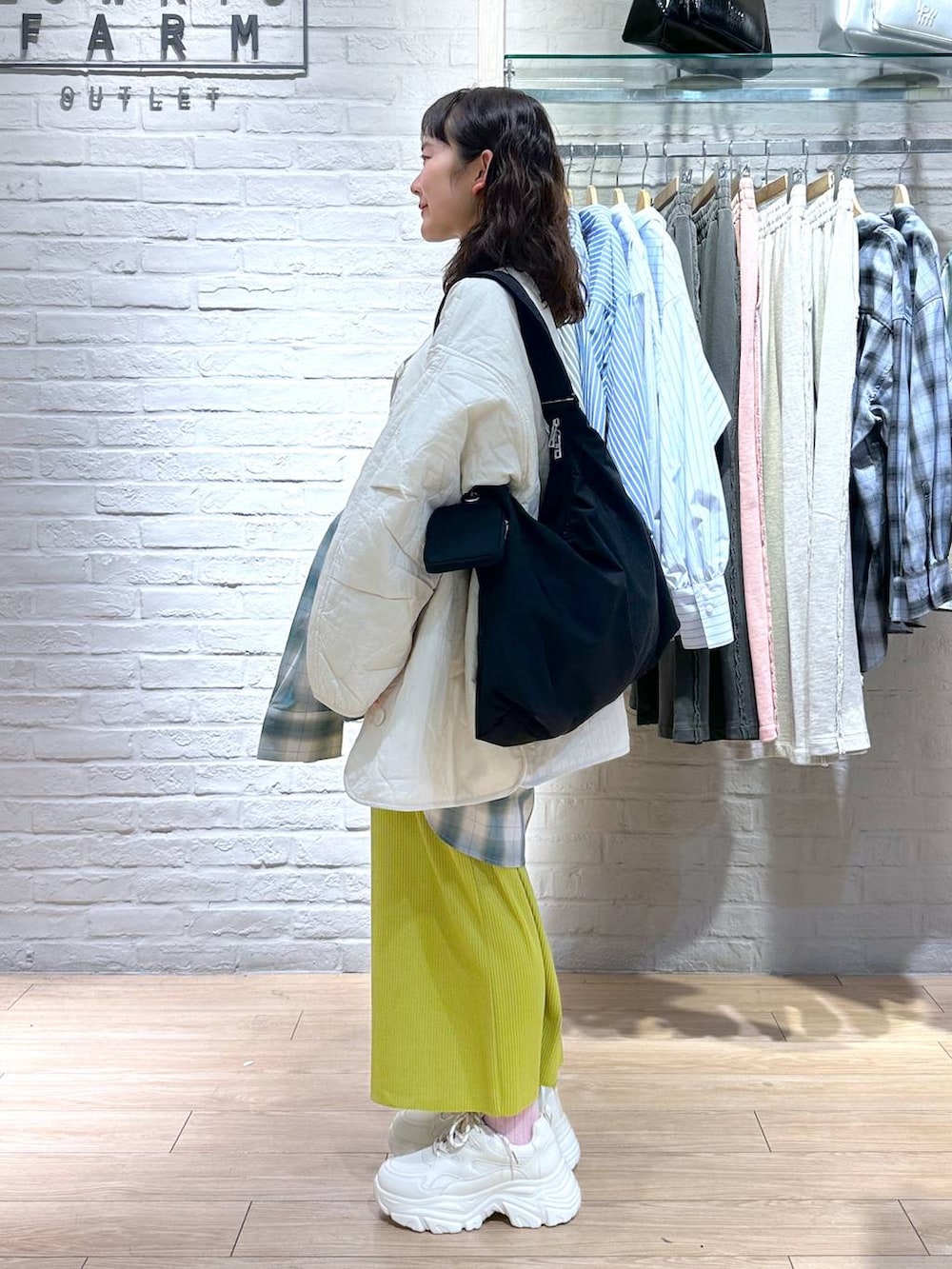 イエロー系のスカート、ホワイト系のブルゾン、ホワイト系のTシャツ/カットソーを着用したレディースの冬コーディネートの4枚目の写真