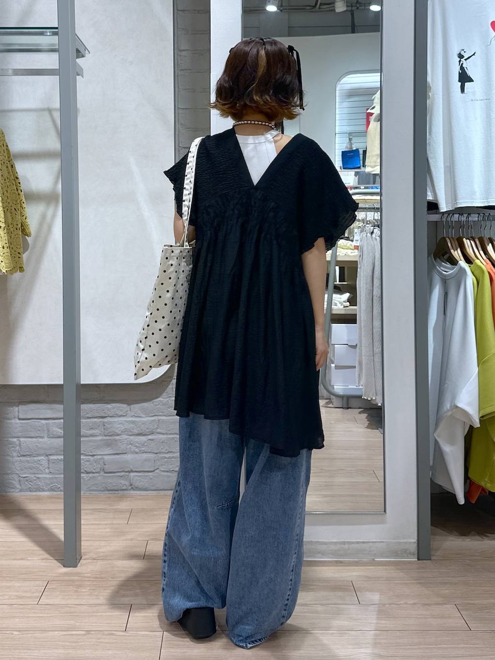 シルバー系のサンダル、その他のトートバッグ、ブルー系のデニムパンツを着用したレディースの夏コーディネートの3枚目の写真