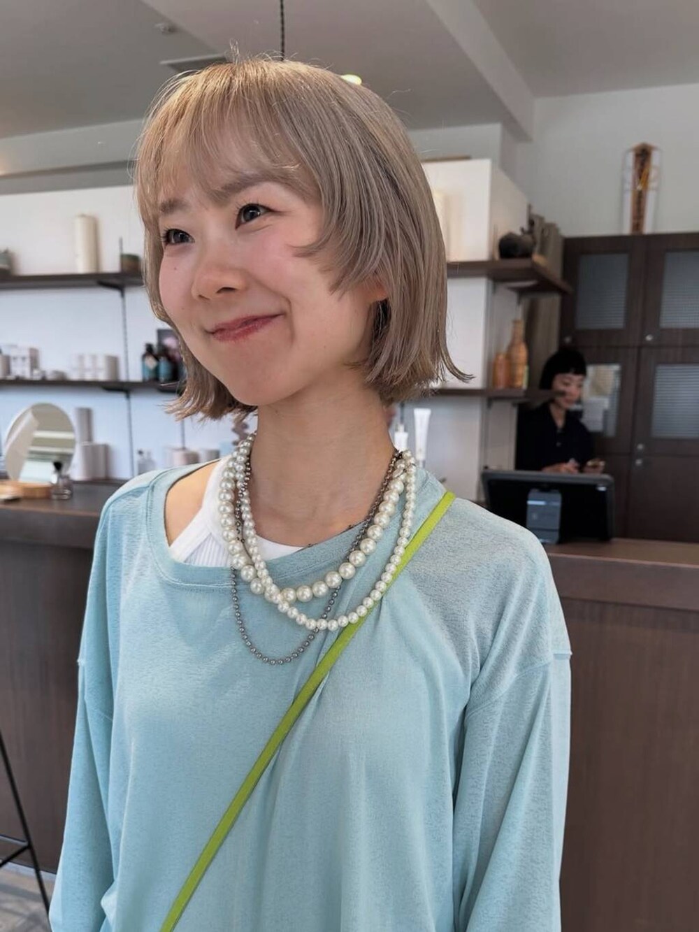 グリーン系のTシャツ/カットソー、ベージュ系のネックレスを着用したレディースの夏コーディネートの3枚目の写真