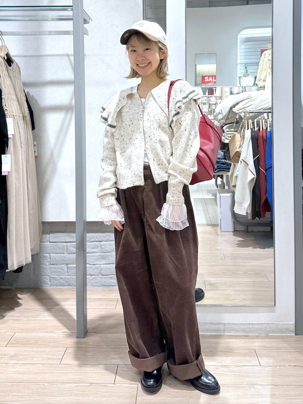 ブラウン系のその他パンツ、ホワイト系のTシャツ/カットソー、ベージュ系のニット/セーターを着用したレディースの秋コーディネートの4枚目の写真