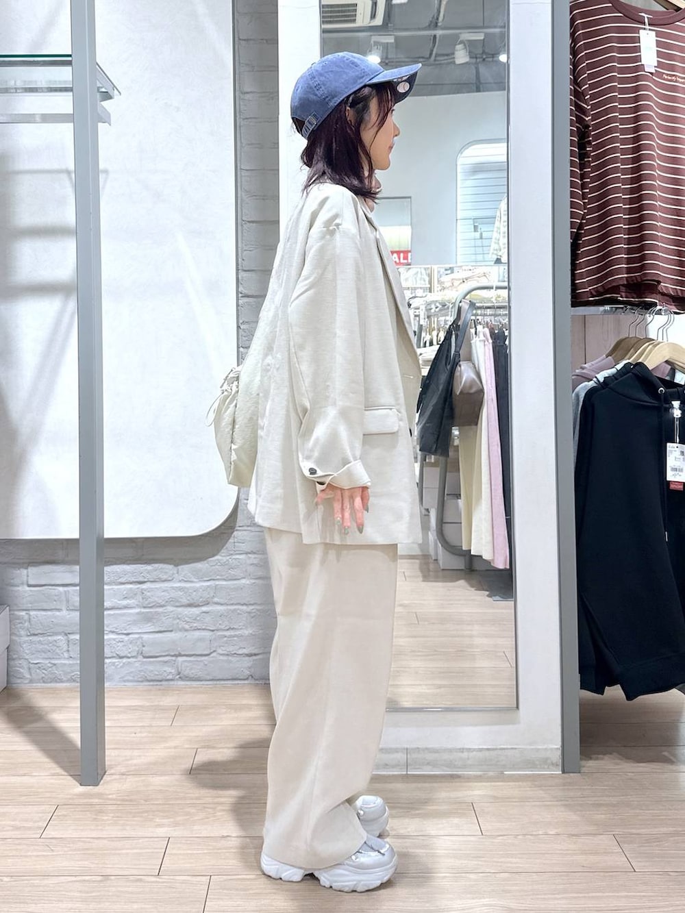 ベージュ系のその他アウター、ベージュ系のその他パンツ、ホワイト系のトートバッグを着用したレディースの春コーディネートの4枚目の写真