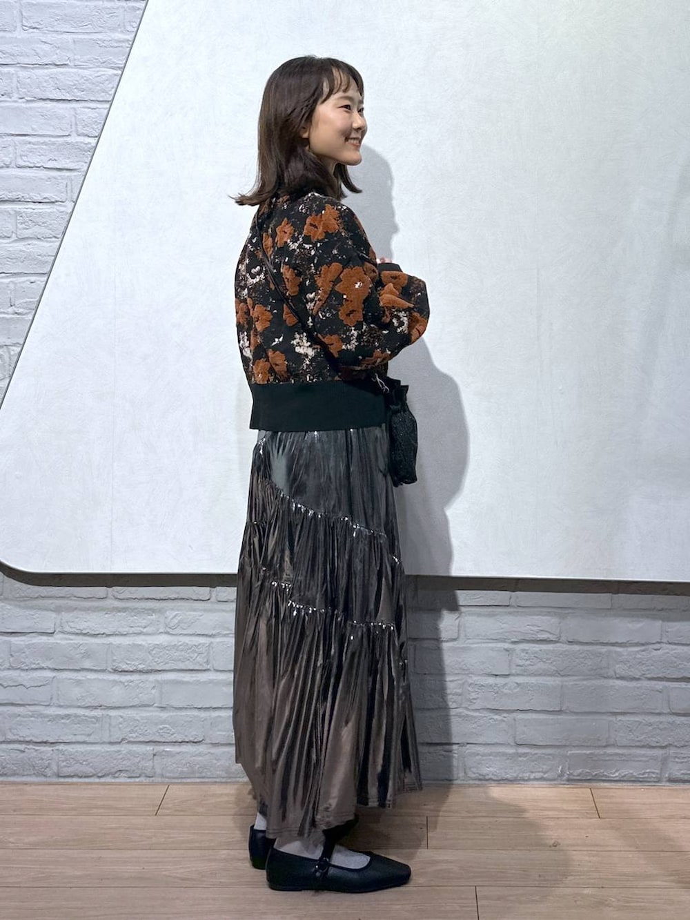 ブラック系のショルダーバッグ、グレー系のスカート、ブラック系のバレエシューズを着用したレディースの秋コーディネートの4枚目の写真