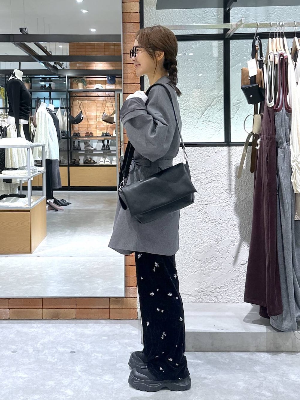 ブラック系のショルダーバッグ、ホワイト系のTシャツ/カットソー、ブラック系のスニーカーを着用したレディースの秋コーディネートの3枚目の写真