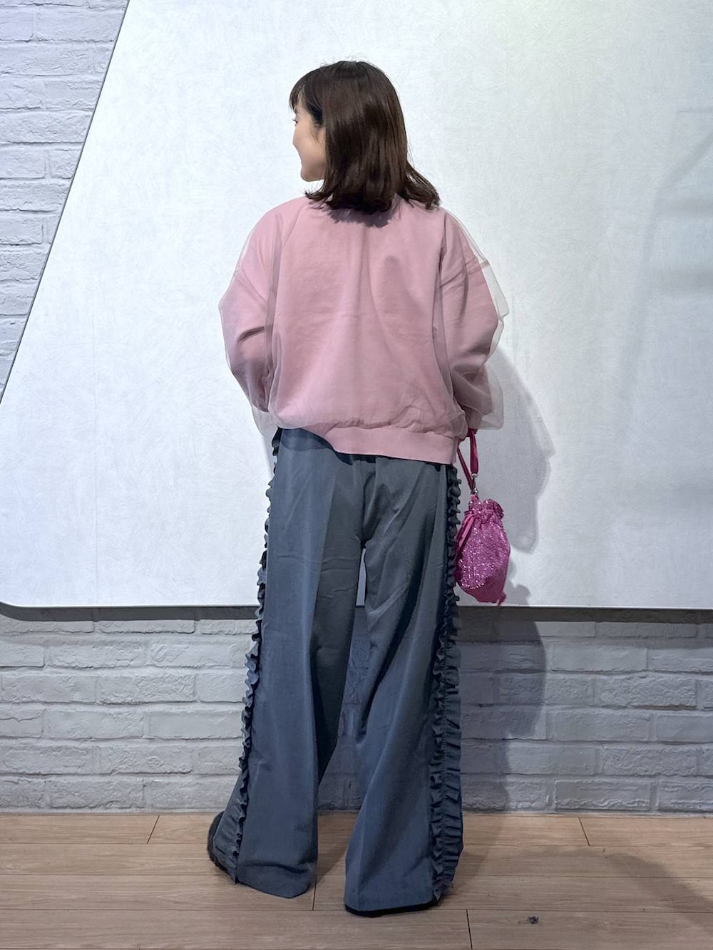 ピンク系のニット/セーター、ブラック系のブーツ、ピンク系のショルダーバッグを着用したレディースの秋コーディネートの4枚目の写真