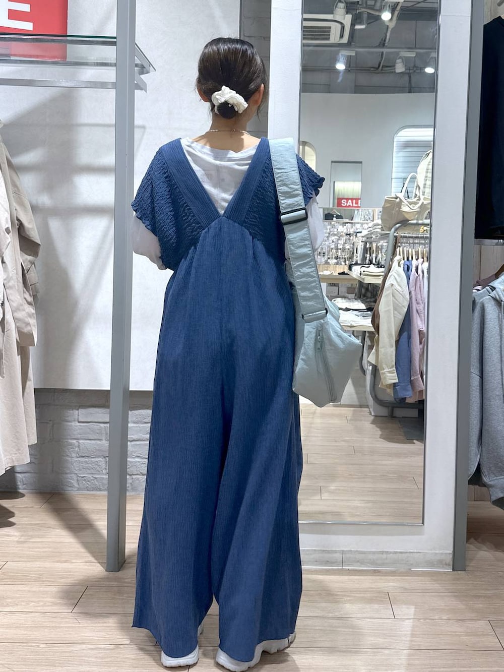 ブルー系のサロペット/オーバーオール、グレー系のTシャツ/カットソー、ブルー系のショルダーバッグを着用したレディースの春コーディネートの5枚目の写真