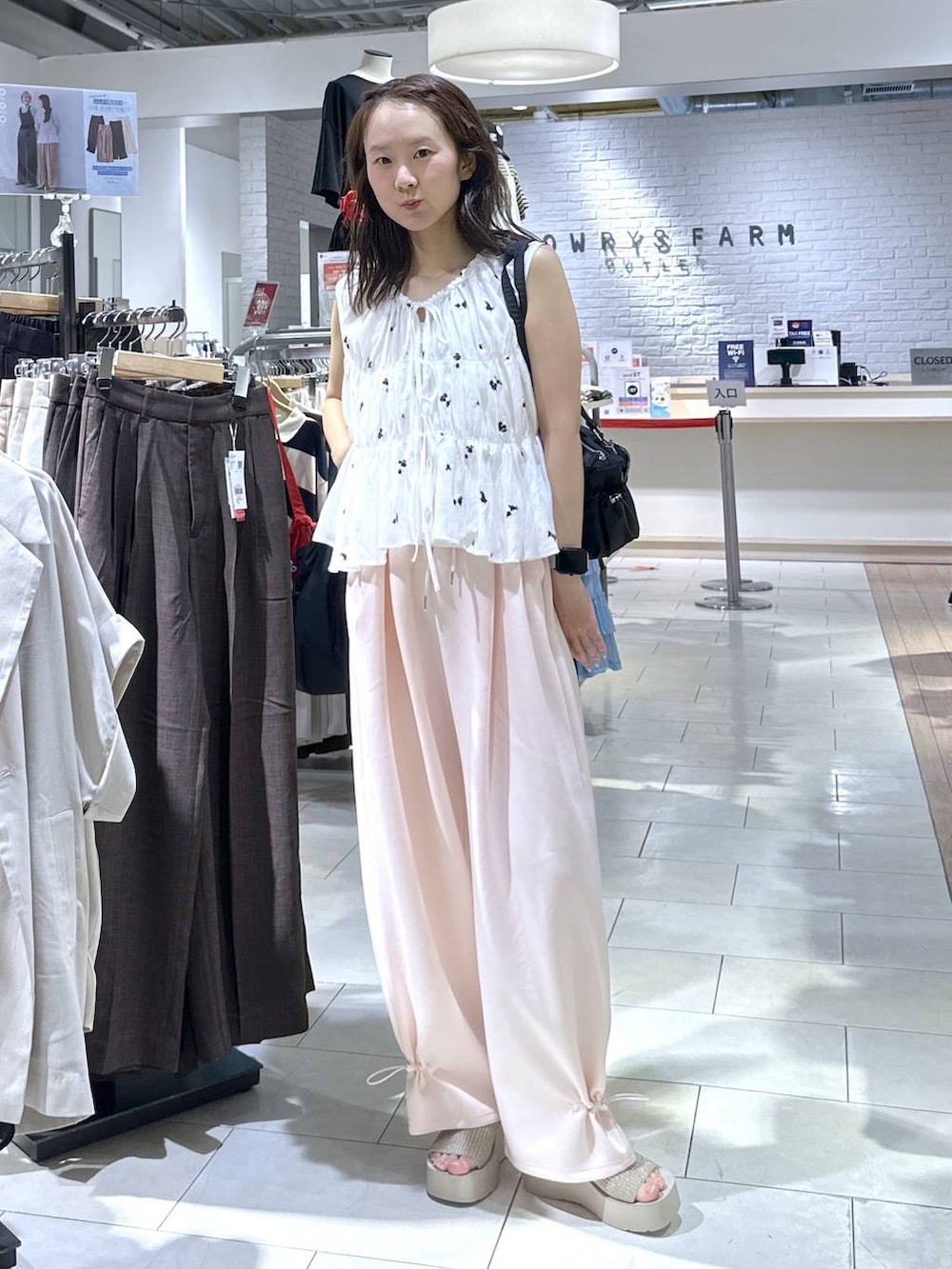 ピンク系のスウェットパンツ、ホワイト系のサンダル、ホワイト系のシャツ/ブラウスを着用したレディースの夏コーディネートの5枚目の写真
