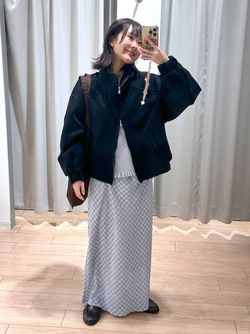 ブラウン系のトートバッグ、ブラウン系のローファー、ブルー系のスカートを着用したレディースの春コーディネートの2枚目の写真