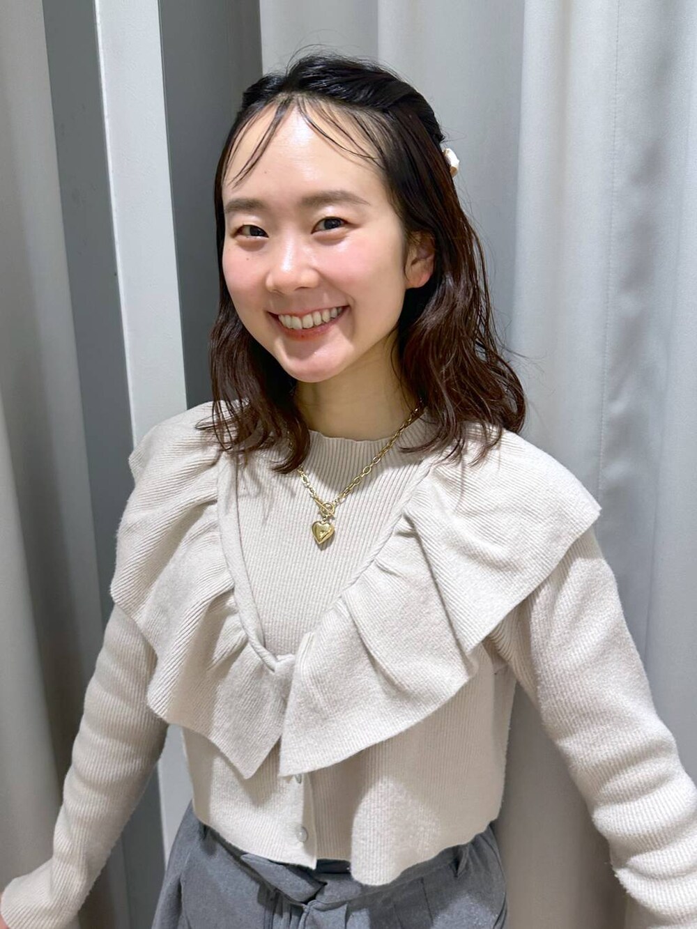 ベージュ系のニット/セーター、ブラウン系のネックレス、ホワイト系のバレッタ/ヘアクリップを着用したレディースの冬コーディネートの6枚目の写真