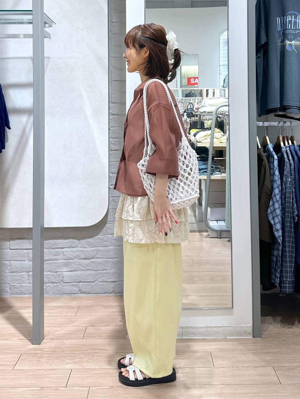 ホワイト系のサンダル、ホワイト系のトートバッグ、ブラウン系のシャツ/ブラウスを着用したレディースの夏コーディネートの2枚目の写真