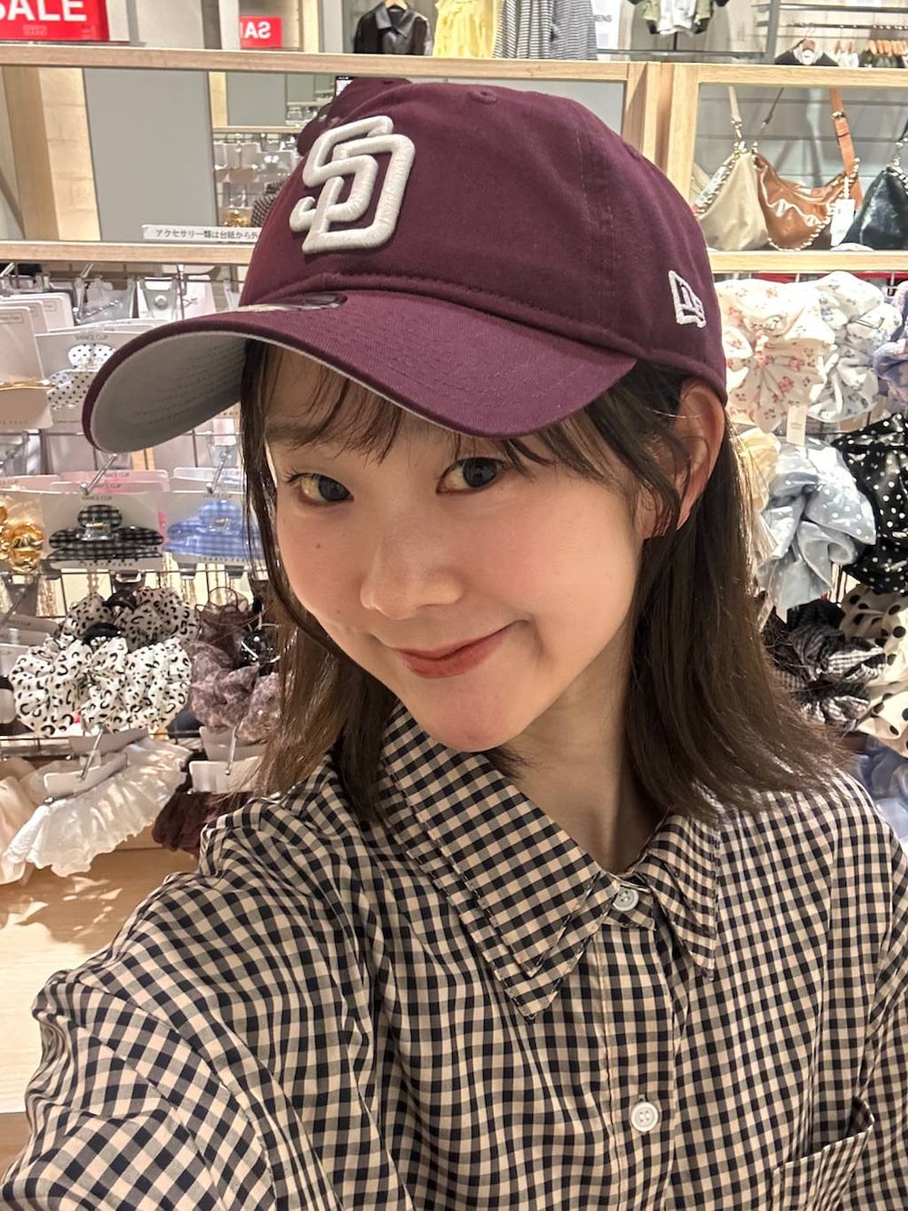 ブラウン系のシャツ/ブラウス、レッド系のキャップを着用したレディースの春コーディネートの3枚目の写真