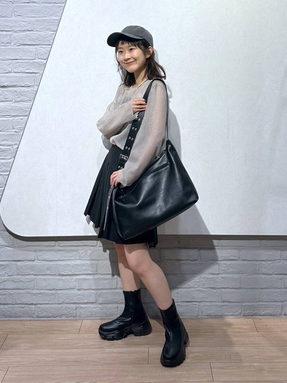 ブラック系のスカート、ブラック系のボディバッグ/ウエストポーチ、ホワイト系のシャツ/ブラウスを着用したレディースの夏コーディネートの2枚目の写真