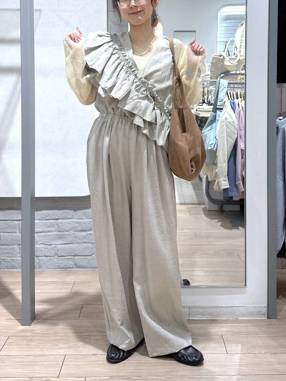 ゴールド系のタンクトップ、ブラック系のローファー、ブラウン系のショルダーバッグを着用したレディースの春コーディネートの5枚目の写真