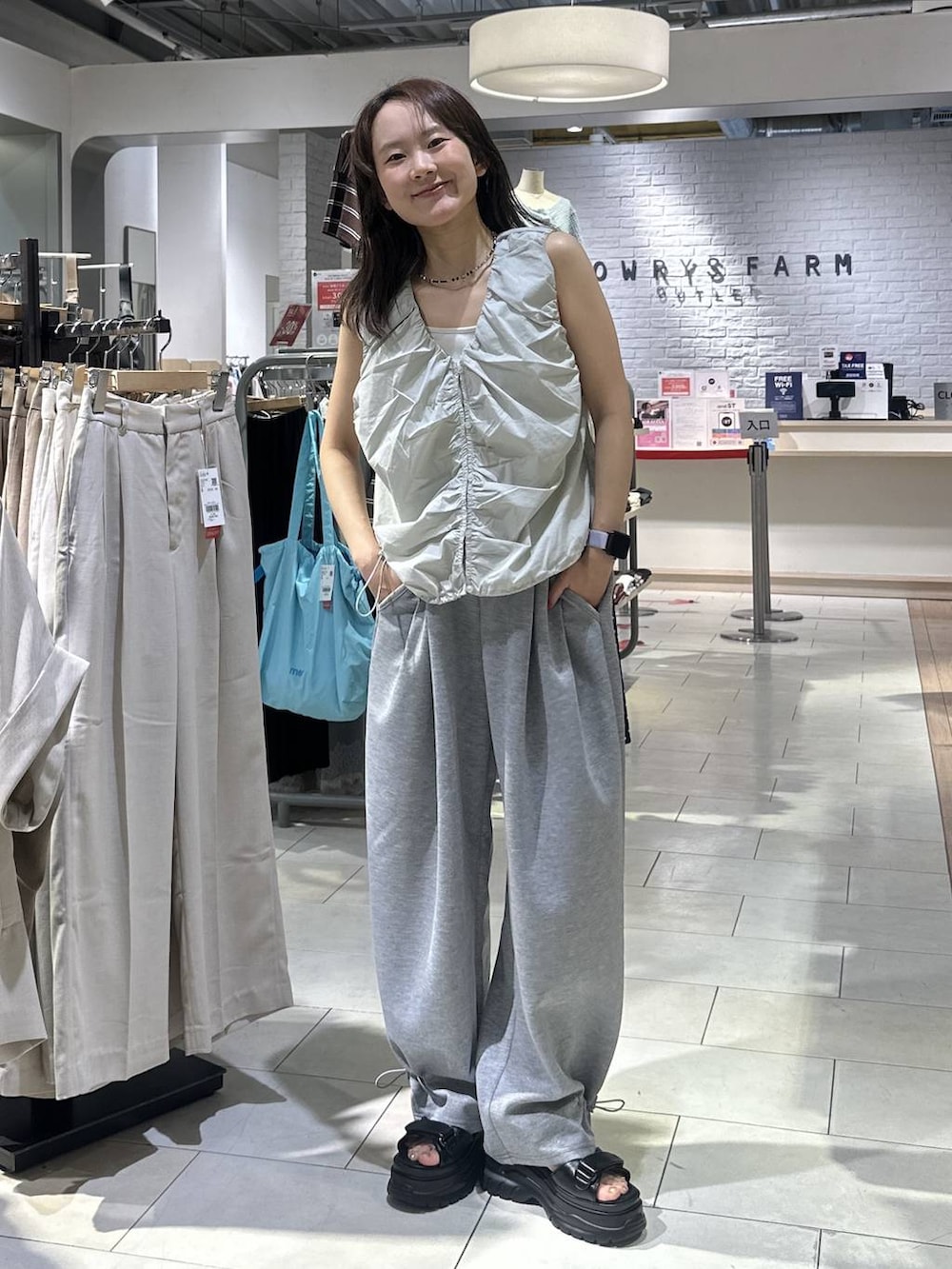 ホワイト系のTシャツ/カットソー、グレー系のスウェットパンツ、ブラック系のサンダルを着用したレディースの夏コーディネートの3枚目の写真
