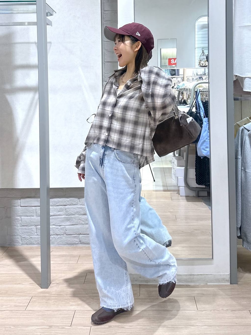 ホワイト系のTシャツ/カットソー、ブルー系のデニムパンツ、ブラウン系のショルダーバッグを着用したレディースの春コーディネートの5枚目の写真