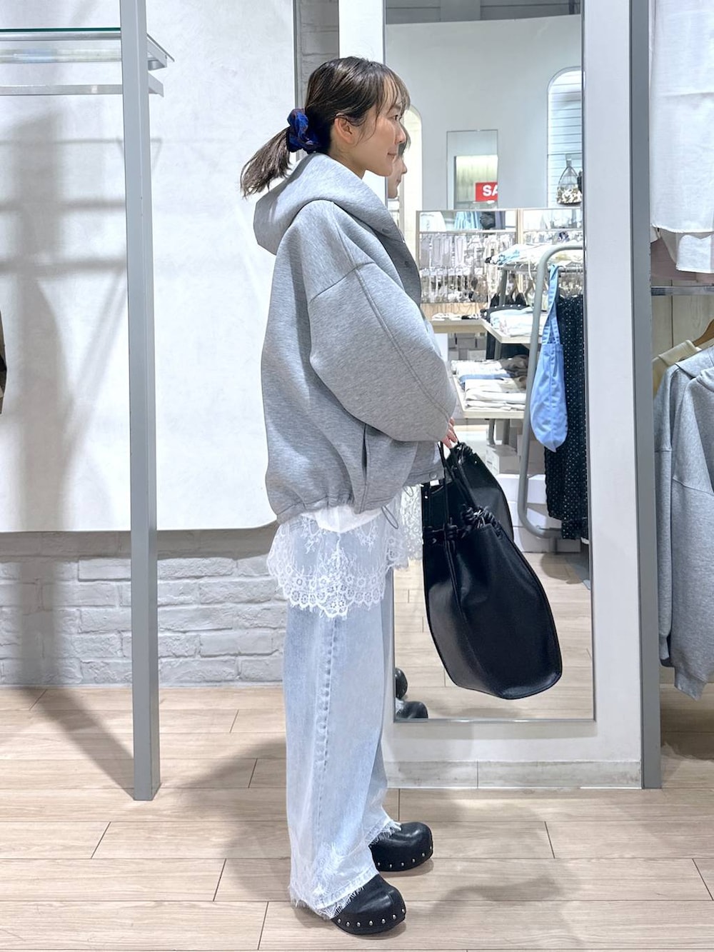 グリーン系のTシャツ/カットソー、ブルー系のデニムパンツ、ブラック系のサンダルを着用したレディースの春コーディネートの2枚目の写真