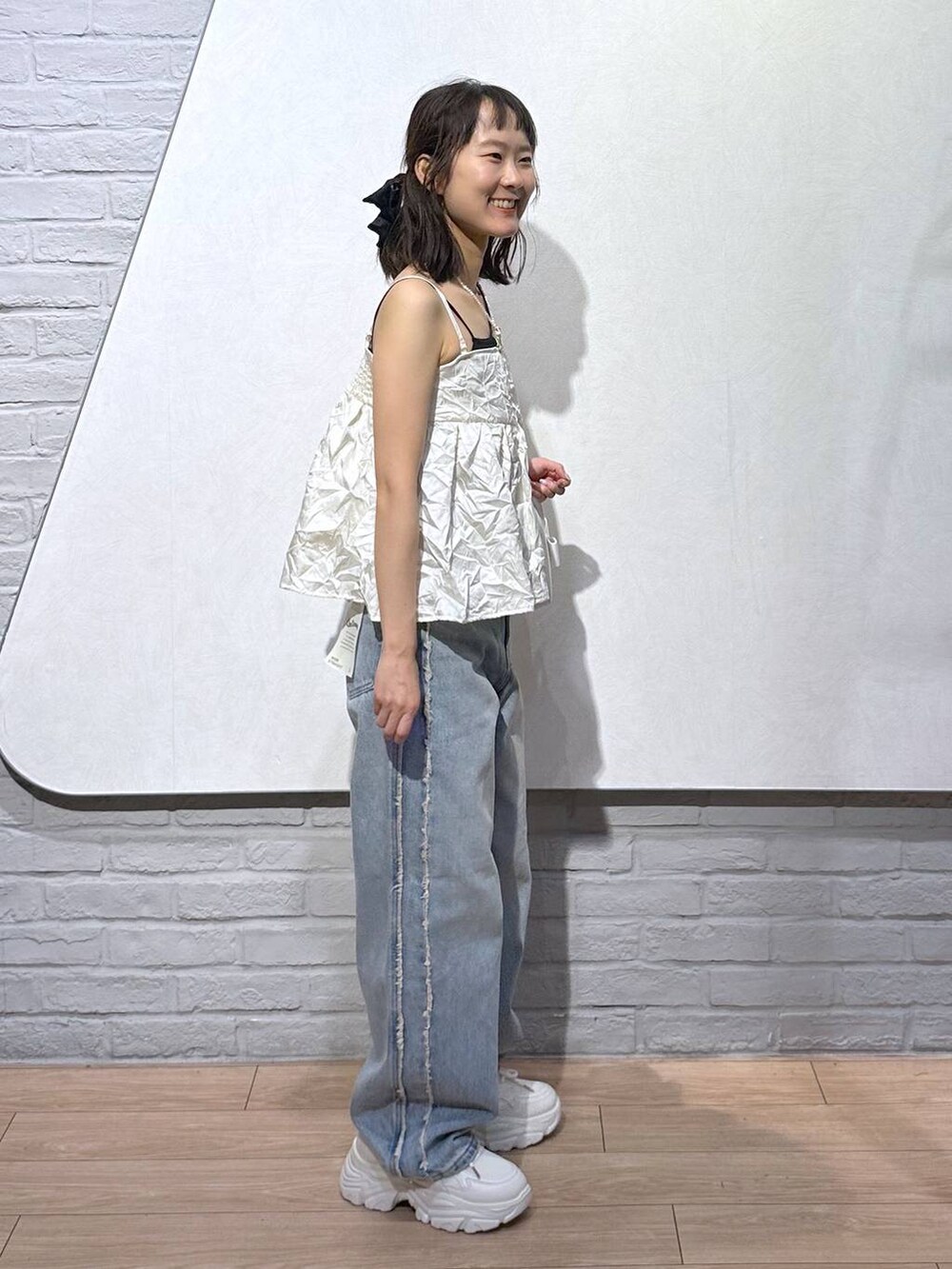 ホワイト系のスニーカー、ブラック系のキャミソール、ホワイト系のボストンバッグを着用したレディースの秋コーディネートの4枚目の写真