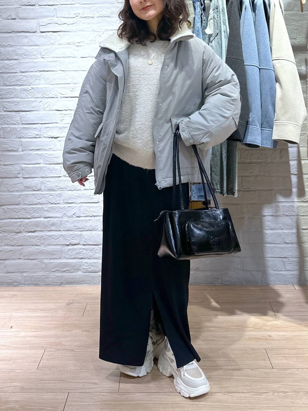 ブラック系のスカート、グリーン系のブルゾン、ベージュ系のスニーカーを着用したレディースの冬コーディネートの2枚目の写真