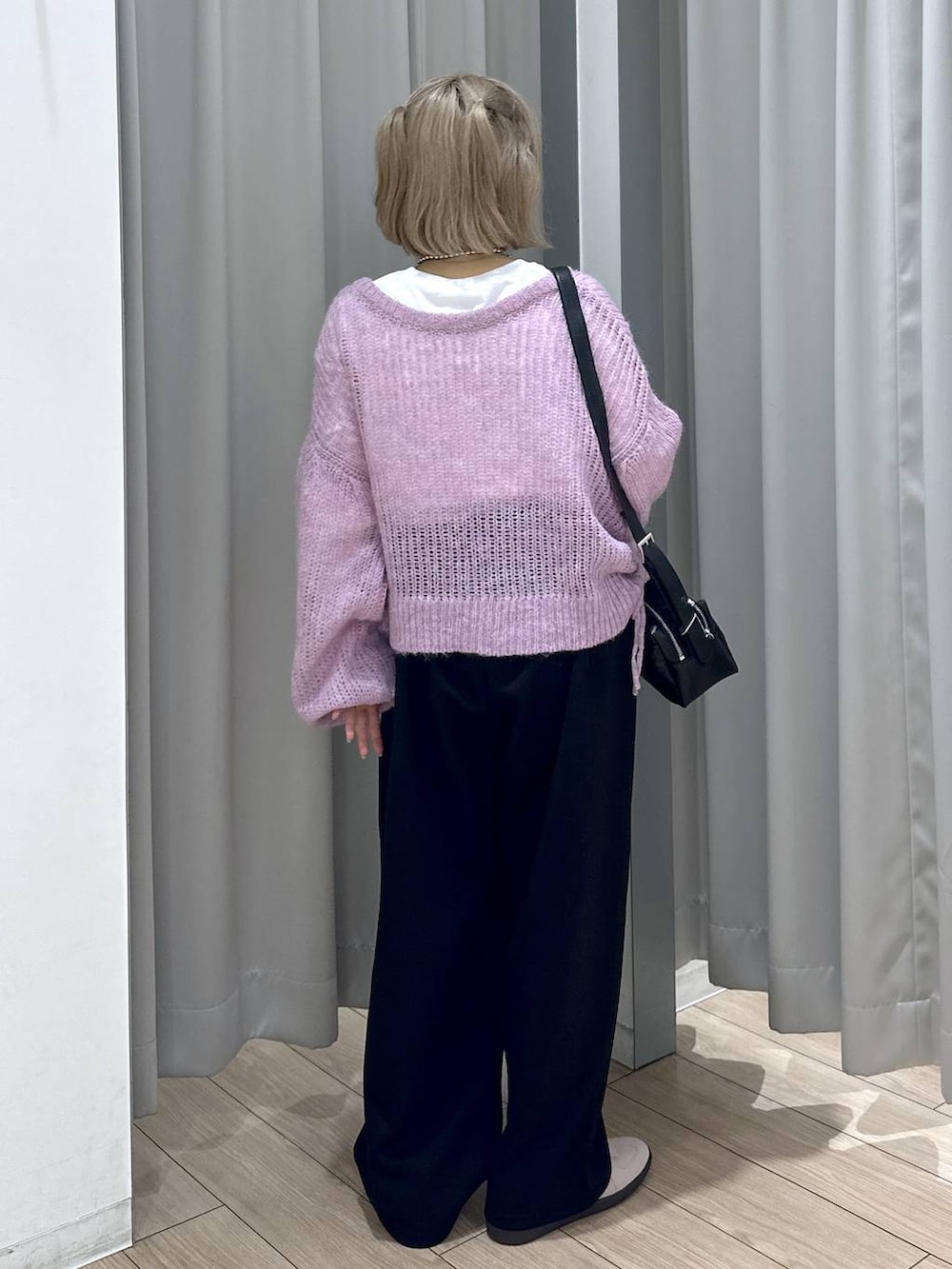 ピンク系のスニーカー、ブラック系のスウェットパンツ、ブラック系のショルダーバッグを着用したレディースの秋コーディネートの5枚目の写真