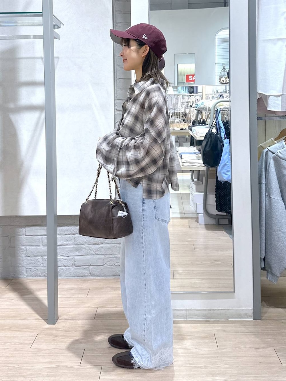 ホワイト系のTシャツ/カットソー、ブルー系のデニムパンツ、ブラウン系のショルダーバッグを着用したレディースの春コーディネートの3枚目の写真