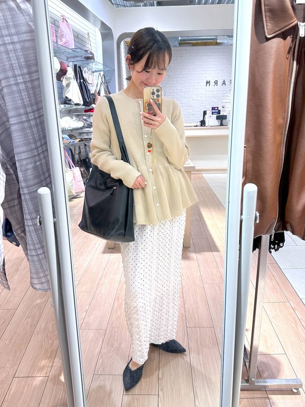 ブラック系のショルダーバッグ、ホワイト系のスカート、ホワイト系のカーディガン/ボレロを着用したレディースの春コーディネートの5枚目の写真